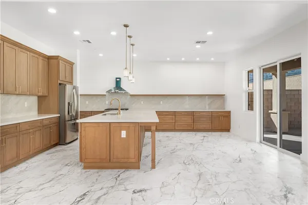 a kitchen with stainless steel appliances granite countertop a sink a stove and a refrigerator