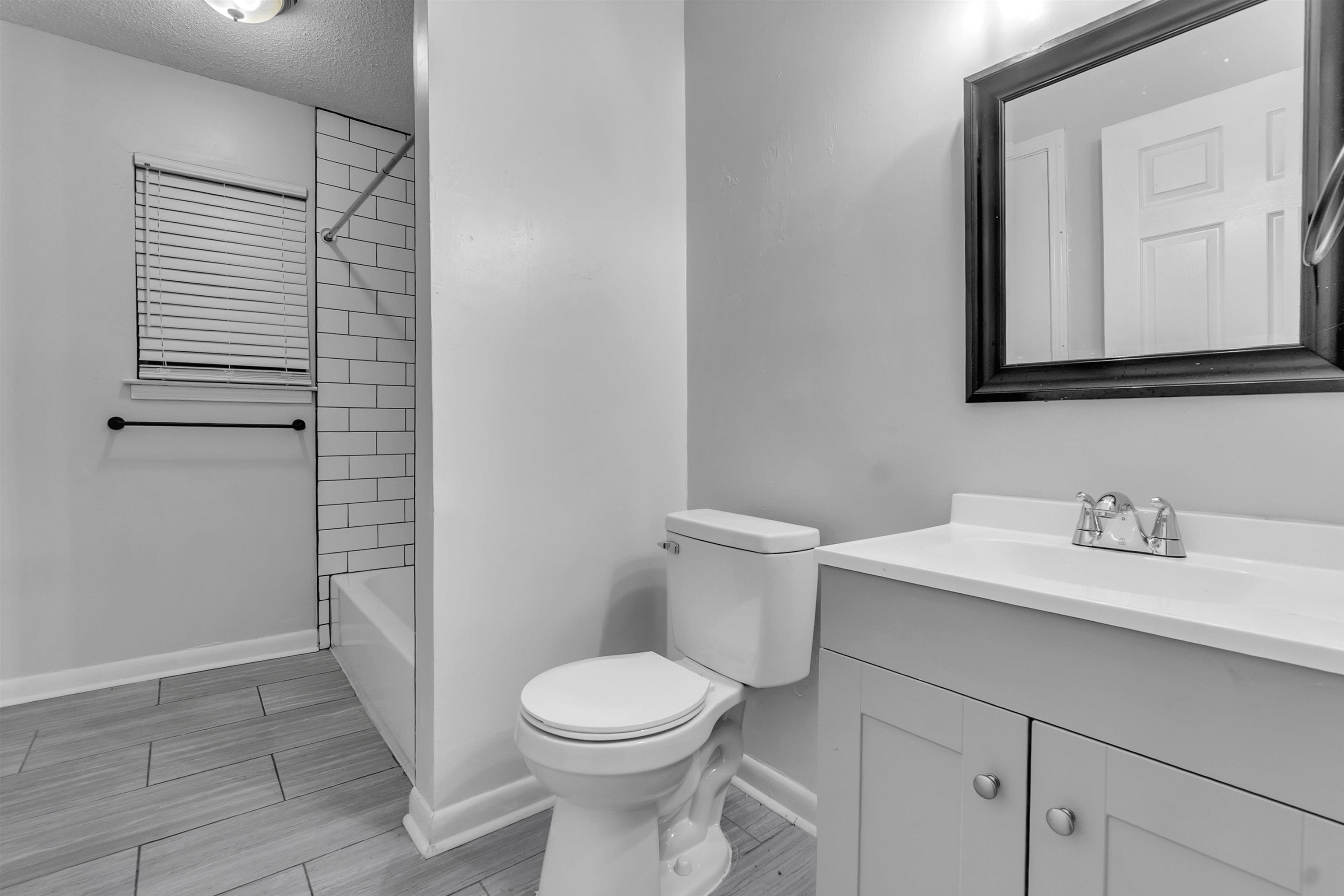 1532 Silver Street Memphis, TN 38106 - Photo 13 of 14 a bathroom with a toilet sink vanity and mirror