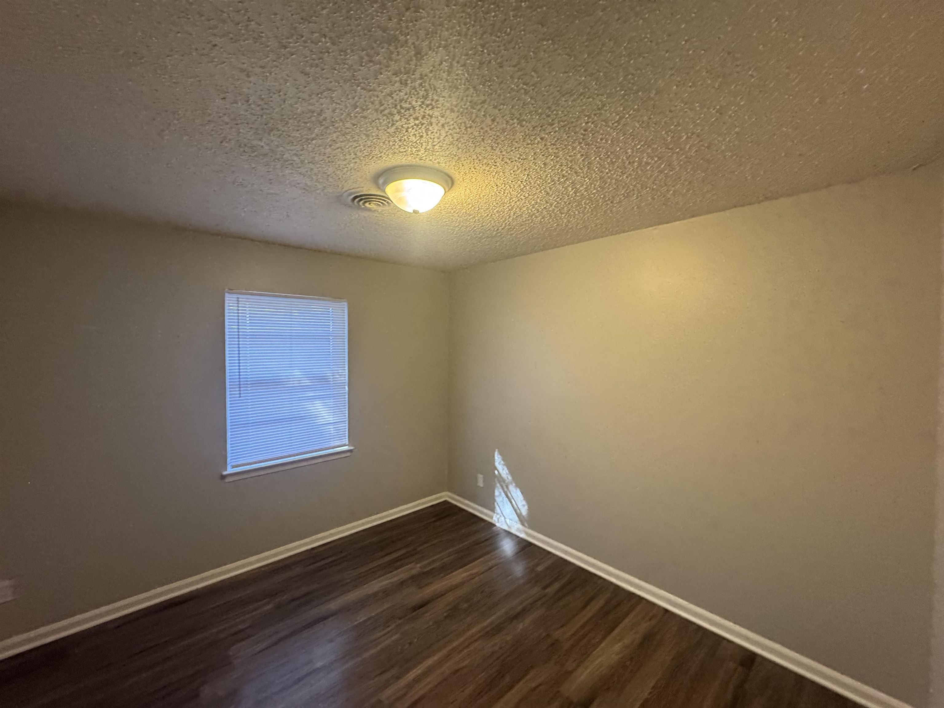 745 Harahan Road Memphis, TN 38109 - Photo 11 of 15 an empty room with wooden floor and windows