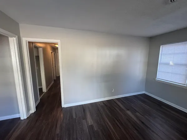 an empty room with wooden floor and closet