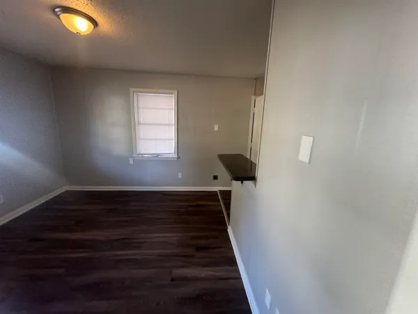 a view of a livingroom with wooden floor and a window