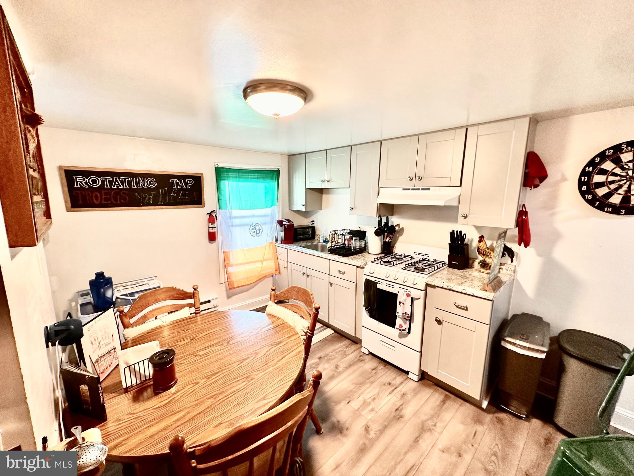 3652 Midvale Avenue, Unit 3 Philadelphia, PA 19129 - Photo 6 of 9 a kitchen with stainless steel appliances granite countertop a stove a sink dishwasher and a refrigerator with wooden floor