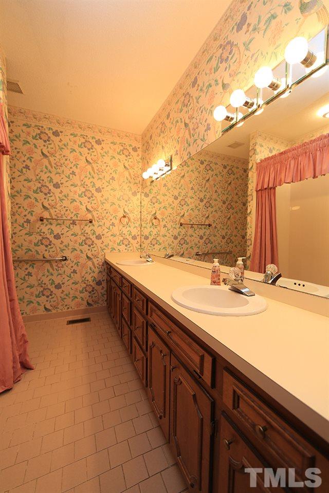 7610 Wilderness Road Raleigh, NC 27613 - Photo 14 of 27 a bathroom with a sink and a vanity