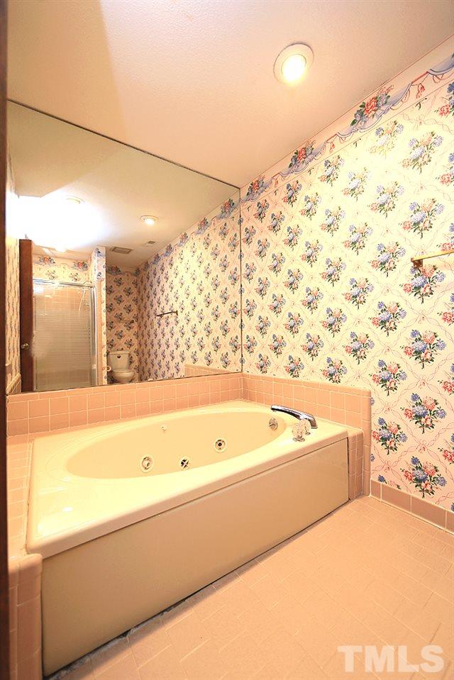 7610 Wilderness Road Raleigh, NC 27613 - Photo 22 of 27 a bathroom with a bathtub and shower
