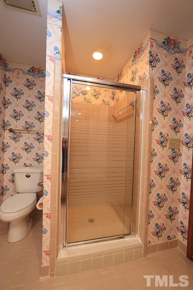 7610 Wilderness Road Raleigh, NC 27613 - Photo 23 of 27 a bathroom with a shower and a toilet