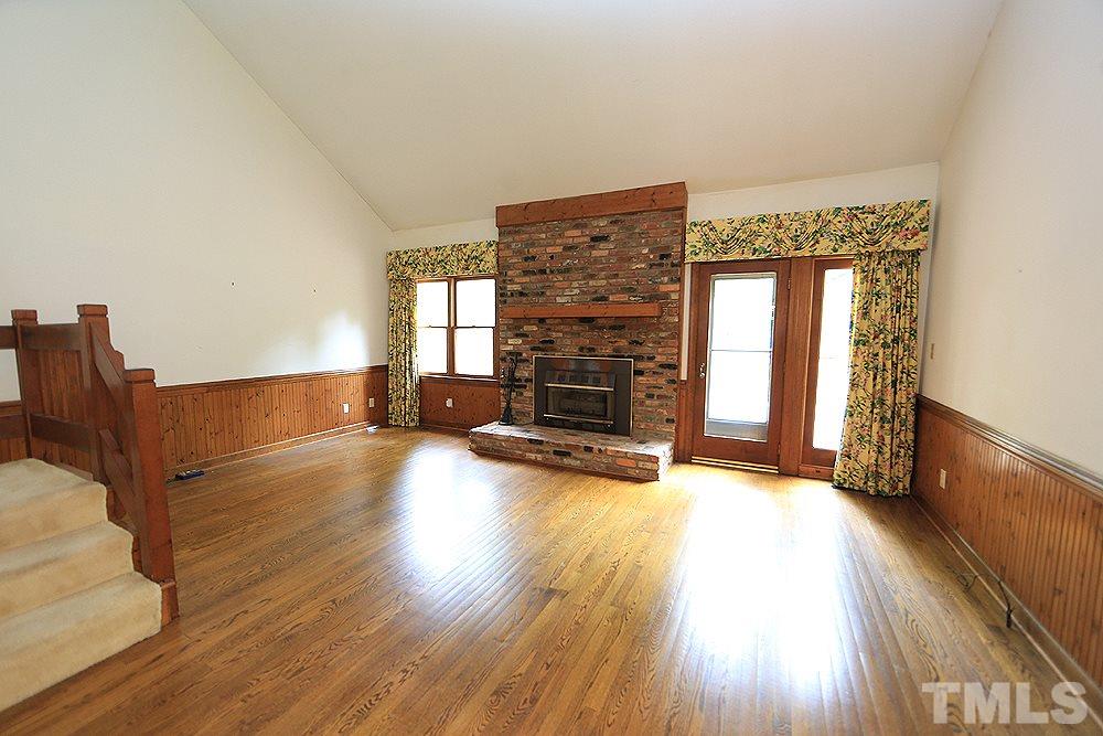 7610 Wilderness Road Raleigh, NC 27613 - Photo 7 of 27 a view of a livingroom with wooden floor and a fireplace