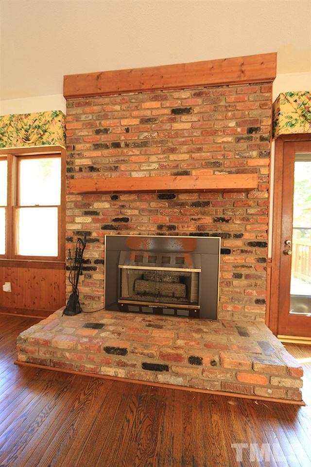 7610 Wilderness Road Raleigh, NC 27613 - Photo 9 of 27 a view of a fireplace with wooden floor