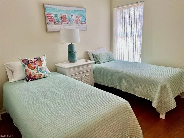 a bedroom with two bed and a window