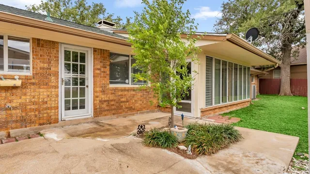 an empty room with chandelier fan and windows