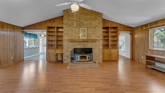 a view of a livingroom with wooden floor and a bathroom