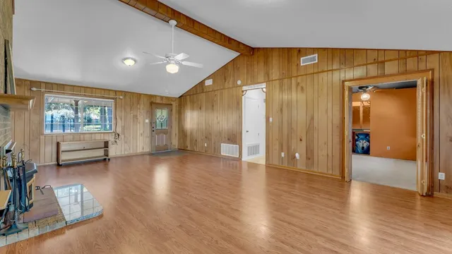 an empty room with a window and a fan
