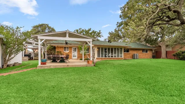 a view of an empty room with wooden floor and a fireplace