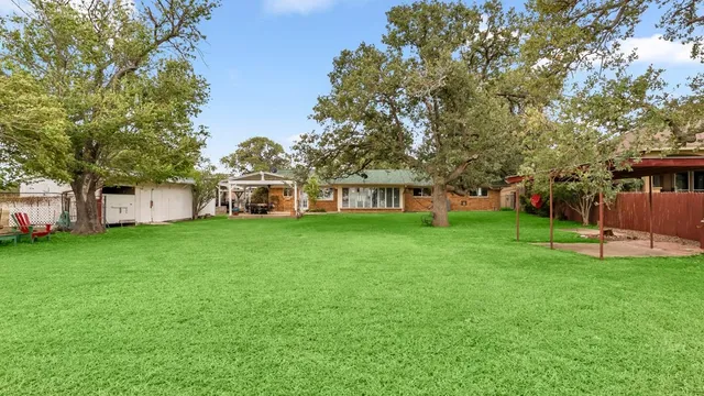 a view of a livingroom with furniture wooden floor fire place and windows