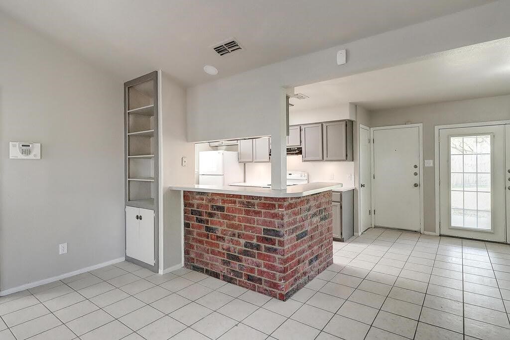 929 St Timothy Street Corpus Christi, TX 78418 - Photo 7 of 35 a kitchen with granite countertop white cabinets and window
