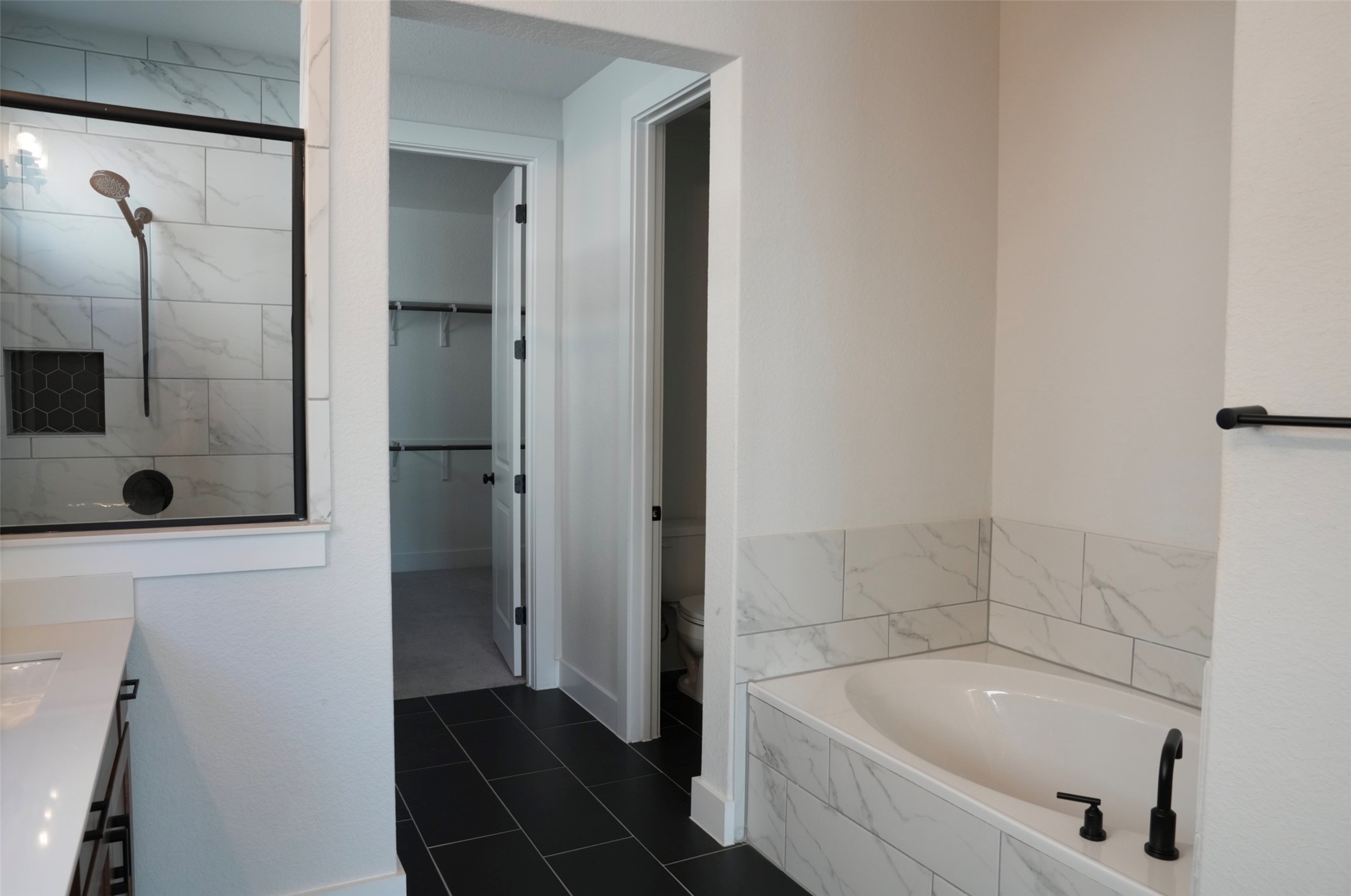 3812 Mercer Road Georgetown, TX 78628 - Photo 17 of 33 Bathroom with vanity, a garden tub, a walk in closet, dark tile patterned flooring, and a marble finish shower