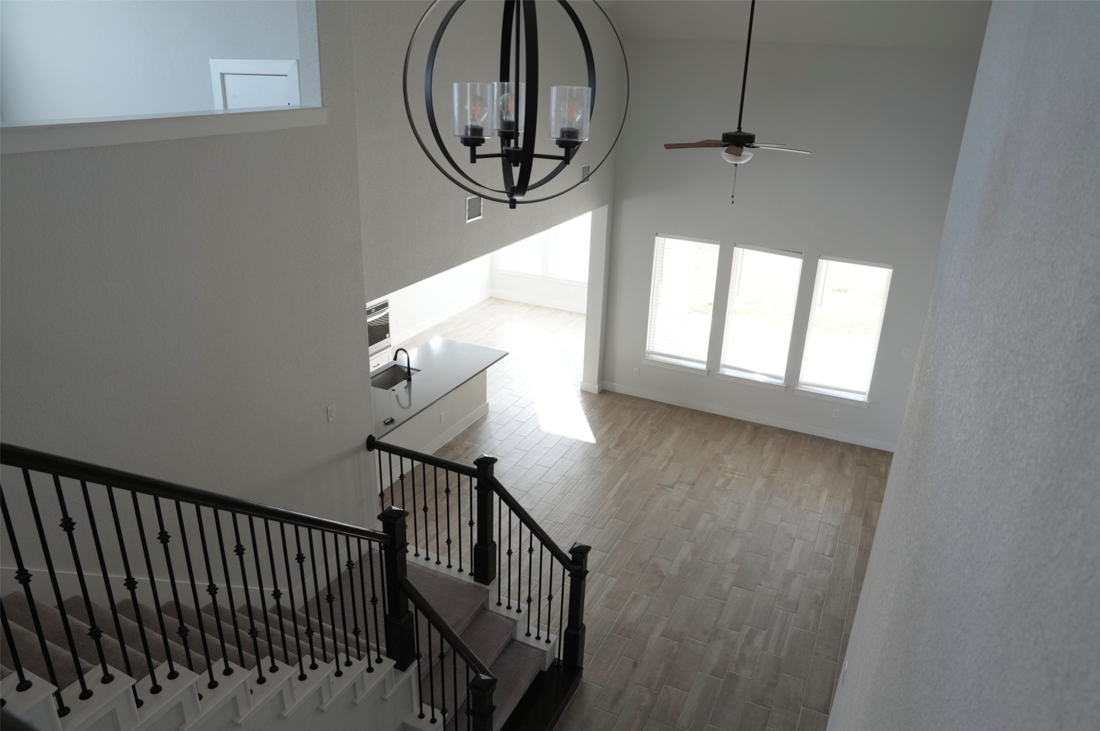 3812 Mercer Road Georgetown, TX 78628 - Photo 21 of 33 Stairway with a chandelier, a high ceiling, wood finished floors, and a ceiling fan