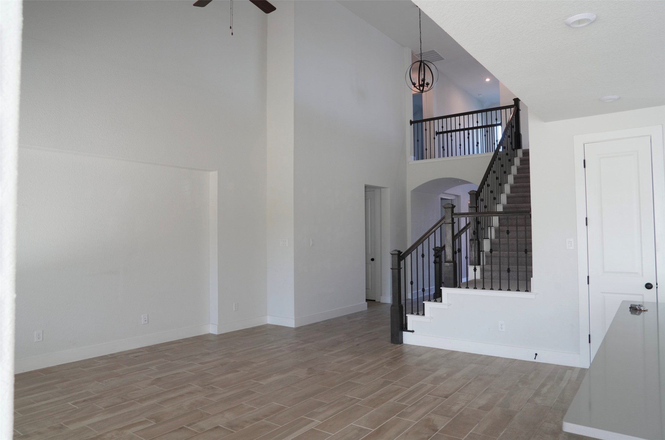 3812 Mercer Road Georgetown, TX 78628 - Photo 26 of 33 Foyer entrance featuring wood tiled floors, a high ceiling, ceiling fan, arched walkways, and hanging lights