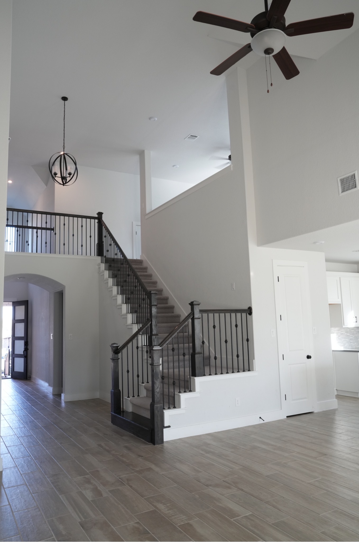 3812 Mercer Road Georgetown, TX 78628 - Photo 5 of 33 Stairs featuring a high ceiling, arched walkways, wood finished floors, a ceiling fan, and hanging lights