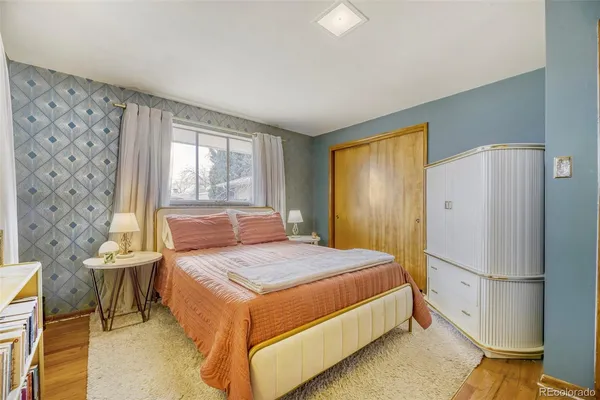 a bedroom with a bed and a refrigerator