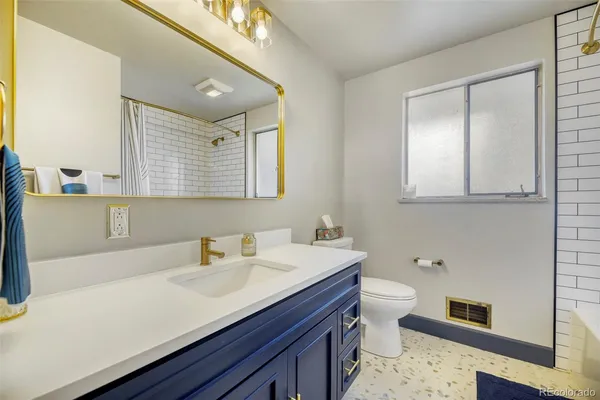 a bathroom with a sink a toilet and mirror