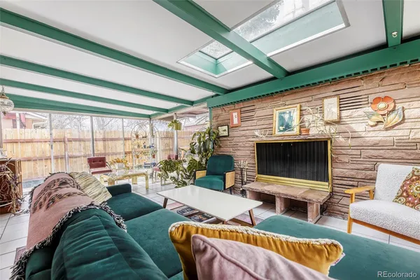a living room with furniture a flat screen tv and a floor to ceiling window
