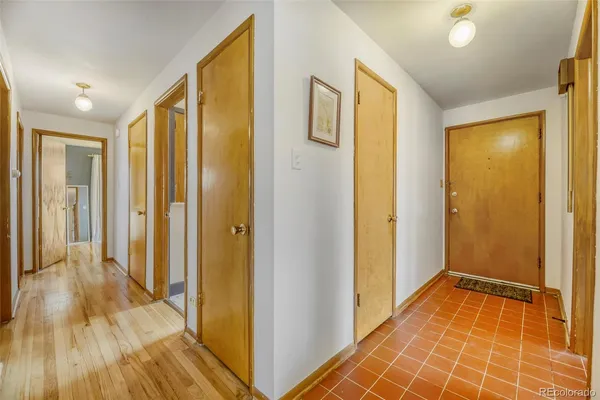 a view of a hallway with wooden floor and bathroom
