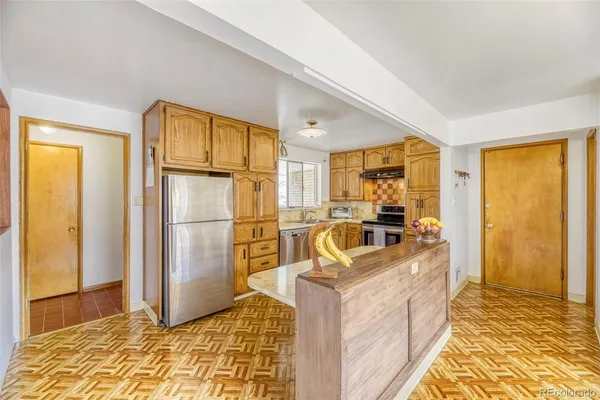 a kitchen with granite countertop a sink refrigerator and cabinets