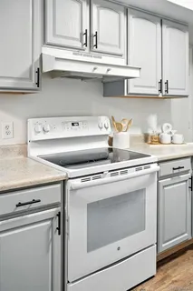 a kitchen with stainless steel appliances granite countertop white cabinets and a sink