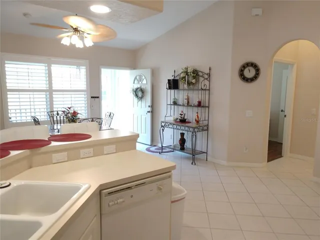 a living room with stainless steel appliances furniture a large window and a chandelier