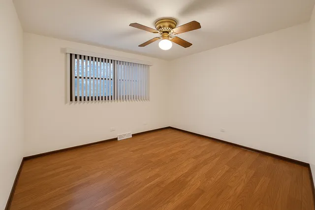 an empty room with a window and a ceiling fan