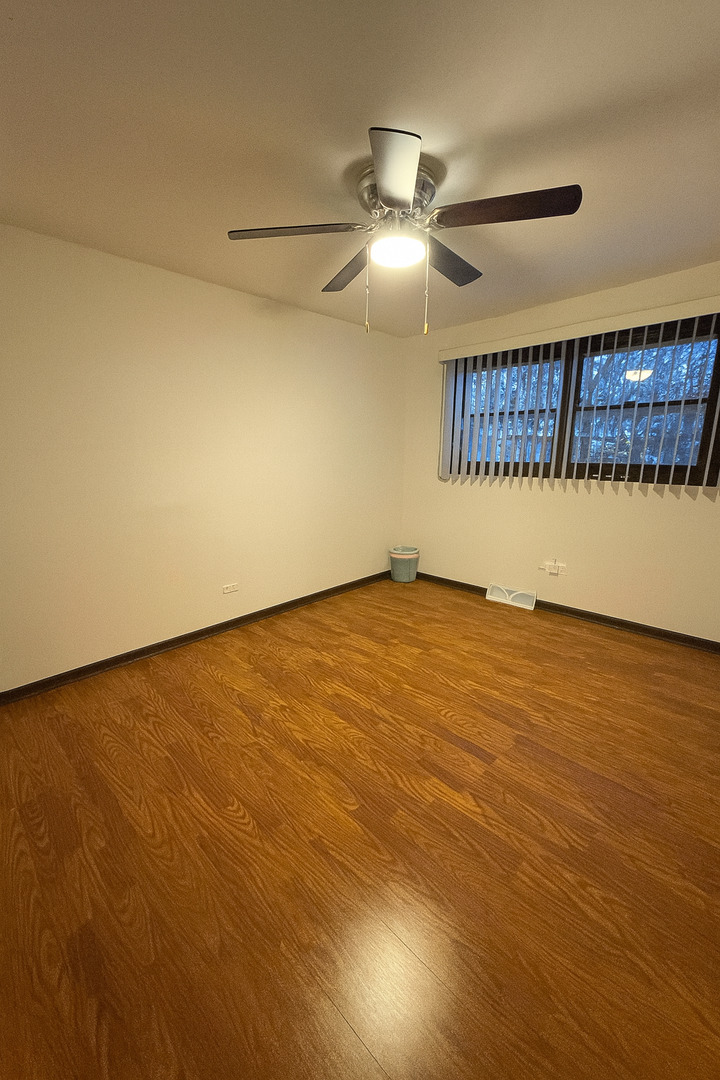 6300 Beaver Dam Road Matteson, IL 60443 - Photo 7 of 11 an empty room with a ceiling fan and wooden floor