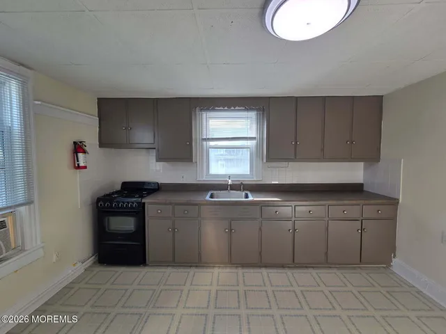 a kitchen with a sink a stove and cabinets