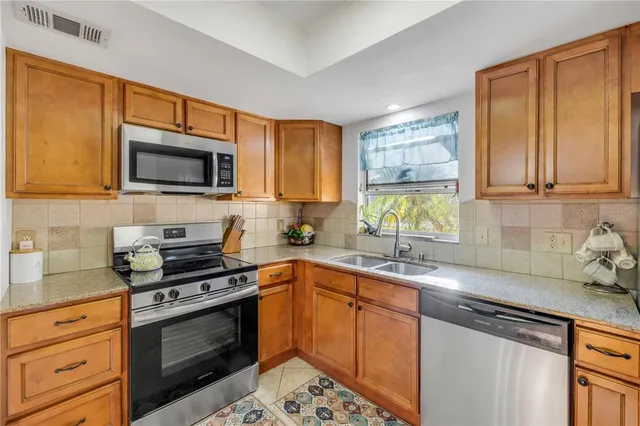a kitchen with stainless steel appliances granite countertop a sink stove microwave and cabinets