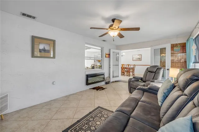 a living room with furniture a ceiling fan and a window