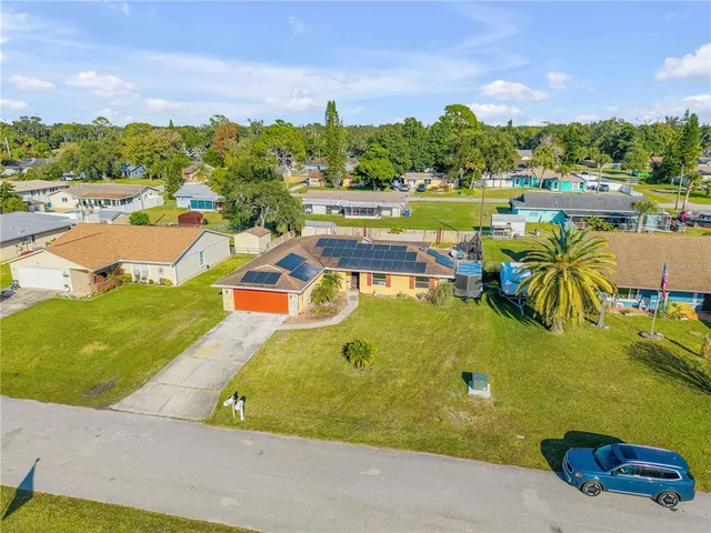 a view of a swimming pool with a lawn chairs under an umbrella