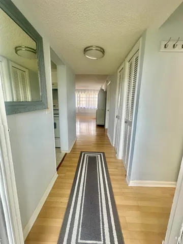 a view of a hallway with wooden floor and staircase