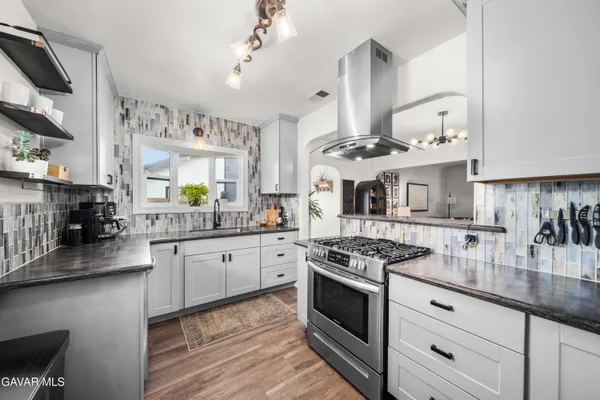 a kitchen with stainless steel appliances granite countertop a stove and cabinets