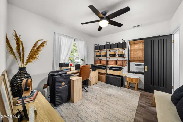 a kitchen with stainless steel appliances a stove a chimney a sink and a dining table with wooden floor