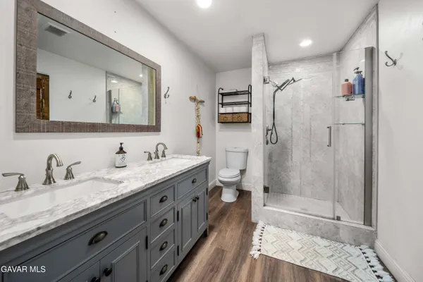 a bathroom with a granite countertop sink mirror shower and double