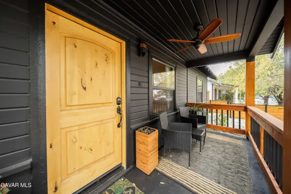a view of an outdoor dining space with wooden floor and furniture