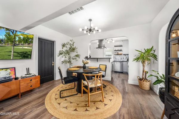 a dining room with furniture potted plants and wooden floor