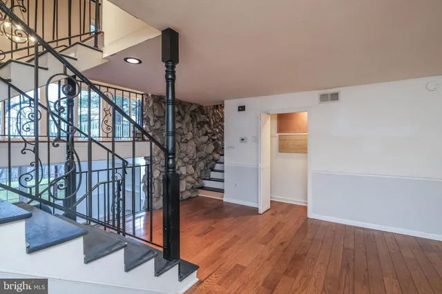 a view of a livingroom with wooden floor a fireplace a book and a window