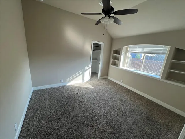 en empty room with windows and ceiling fan