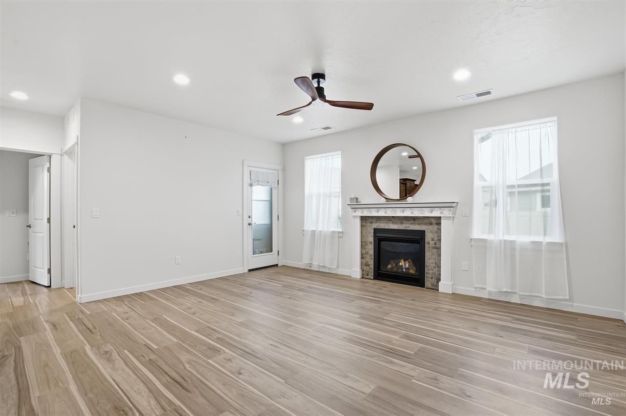 449 West Winnipeg Street Meridian, ID 83642 - Photo 4 of 49 Unfurnished living room featuring a glass covered fireplace, ceiling fan, recessed lighting, and light wood finished floors
