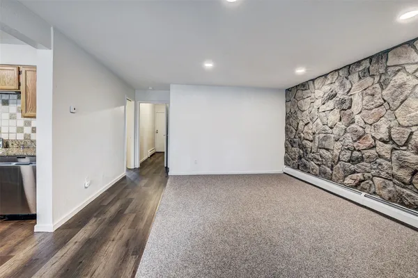 a view of a hallway with wooden floor and a cabinet