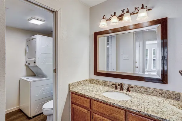 a bathroom with a granite countertop sink a toilet and a mirror