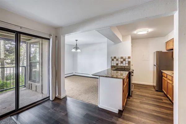 a kitchen with granite countertop a refrigerator and a stove top oven