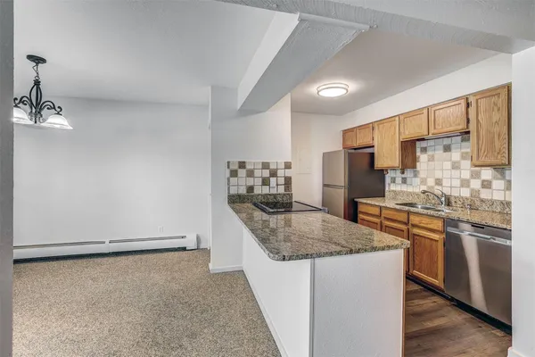 a kitchen with stainless steel appliances granite countertop a sink stove and refrigerator