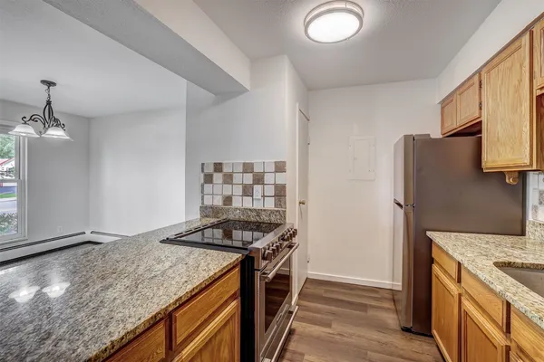 a kitchen with stainless steel appliances granite countertop a sink stove and refrigerator