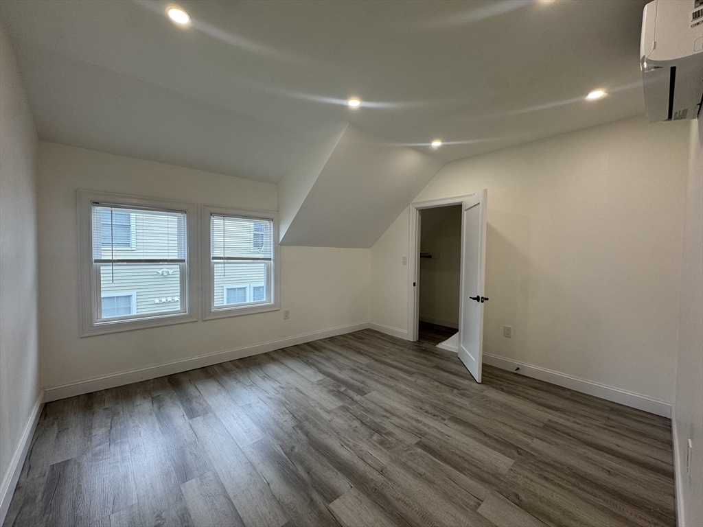 16 Adams Street, Unit 1 Boston, MA 02136 - Photo 11 of 15 an empty room with wooden floor and windows